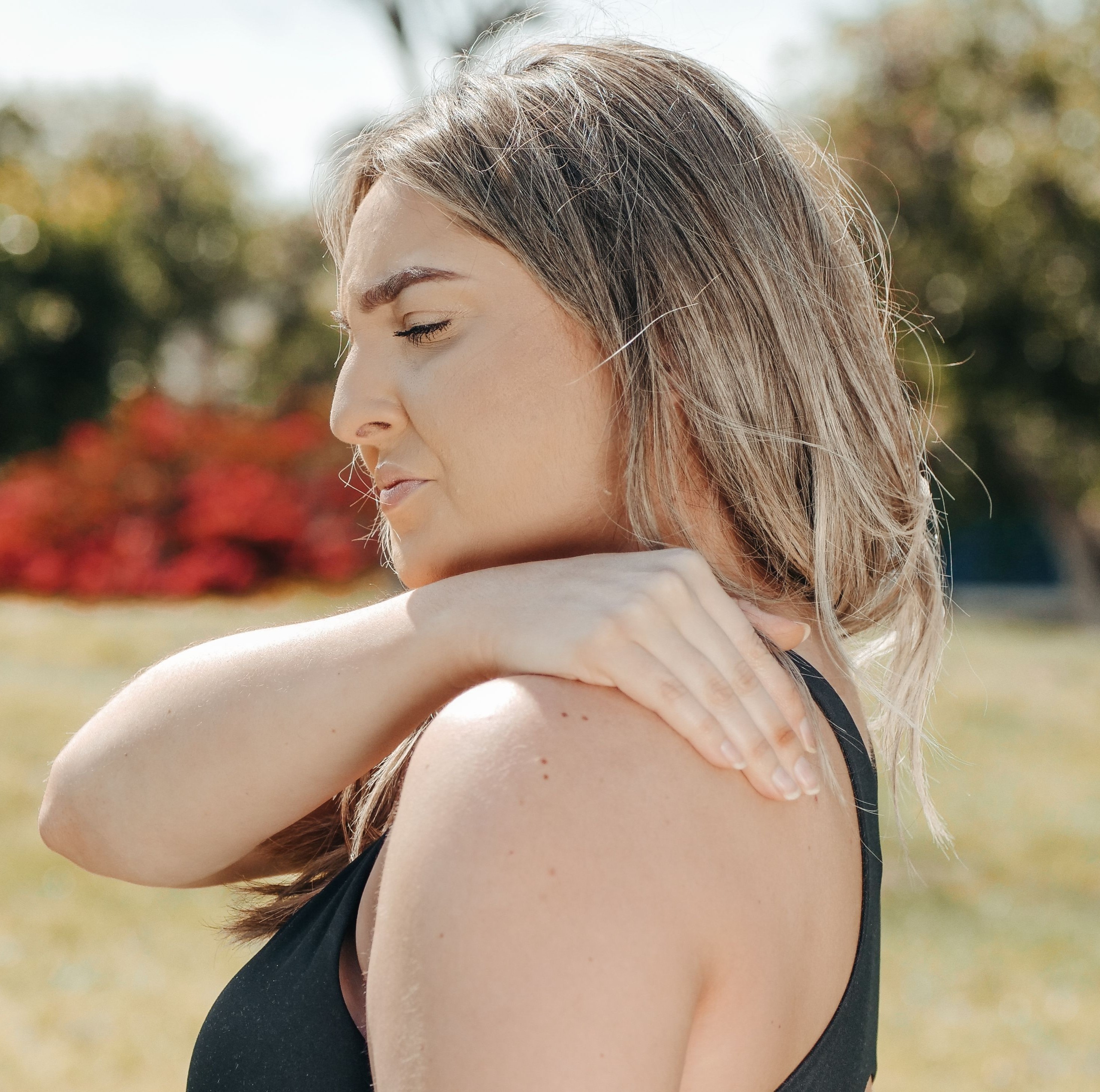 Woman touching her tight shoulder